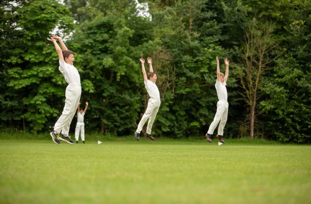 young cricket players jumping in the air