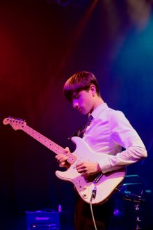 teenage boy playing electric guitar