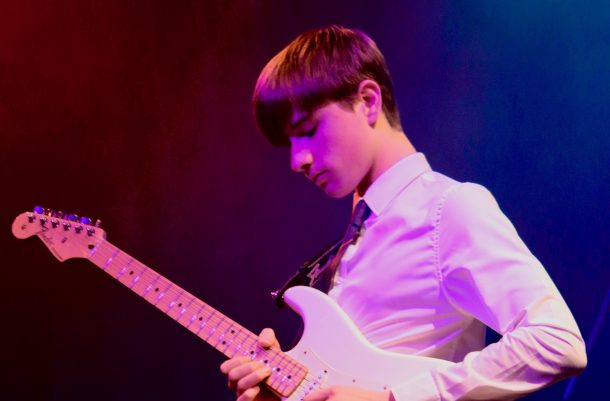 teenage boy playing electric guitar