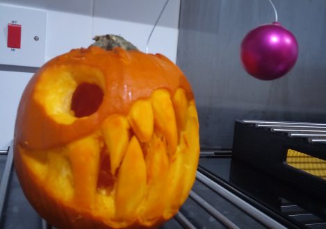 A football fish being carved into a small pumpkin