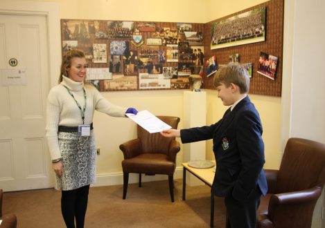 Teacher handing school boy exam results