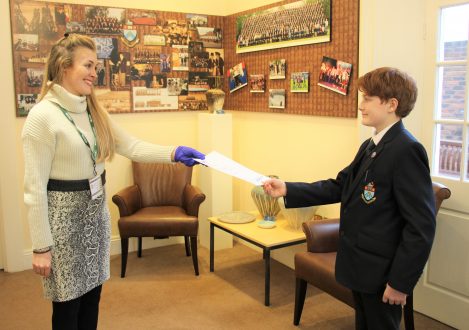 Teacher handing Halliford School student LAMDA exam certificate