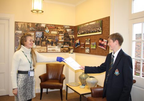 Teacher handing Halliford School student exam results