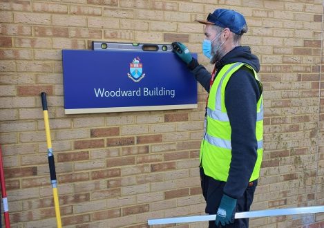 Woodward Building sign being put up on the brick wall