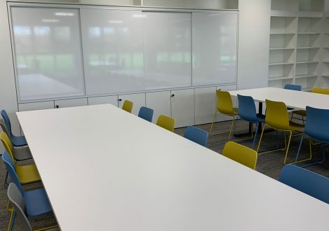 Whiteboards and long tables with chairs