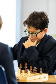 Student thinking about his next move as he plays chess