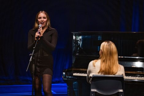 girl singing whilst another girl plays piano