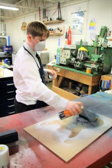 Student spraying onto a work surface