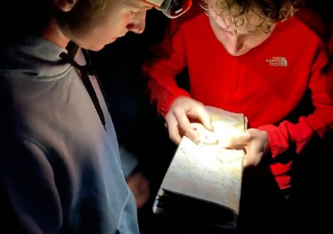 Student using a head torch to light up a map