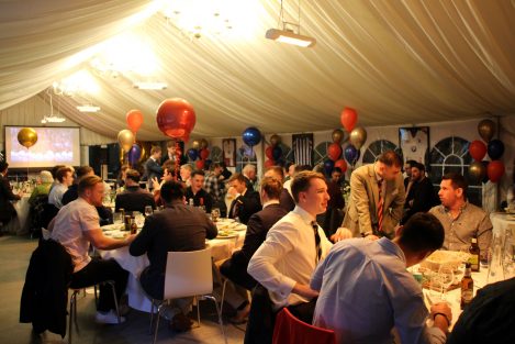 a large group of men having discussions around tables at the hall of fame