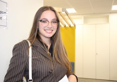 girl in blazer and glasses smiling