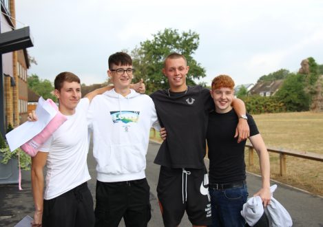 children stood outdoors with their exam results