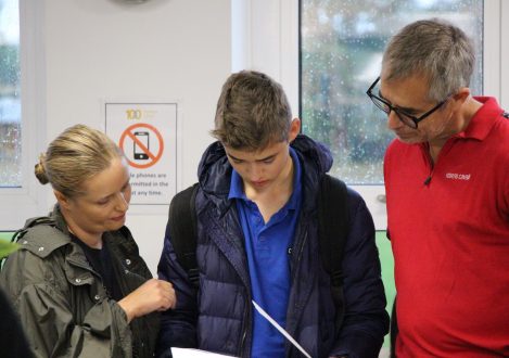 child with his parents as he opens his results