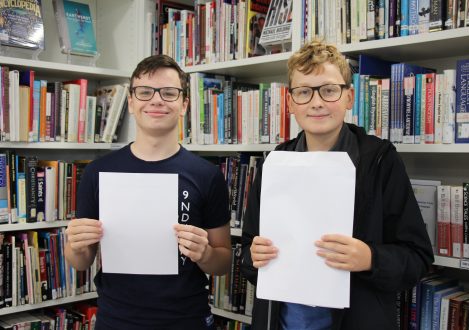 children holding a sheet of paper and envolope