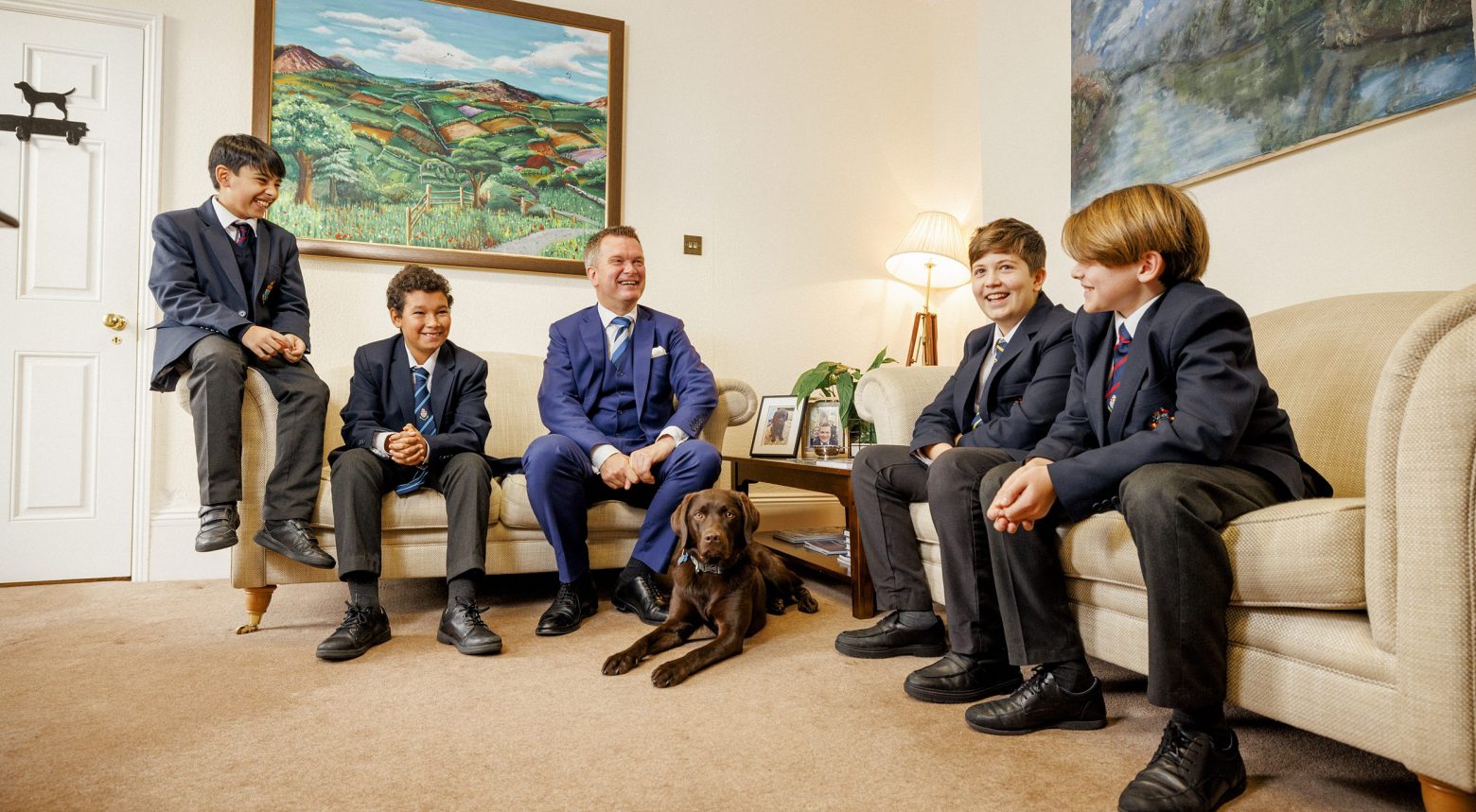 children and teacher sat on sofas