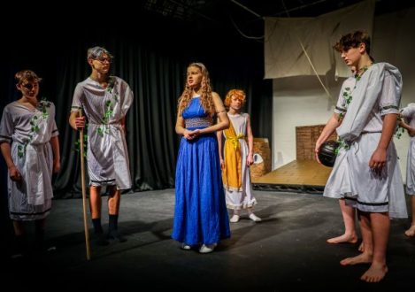 boys stood around a girl wearing a blue dress