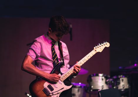 student playing the electric guitar