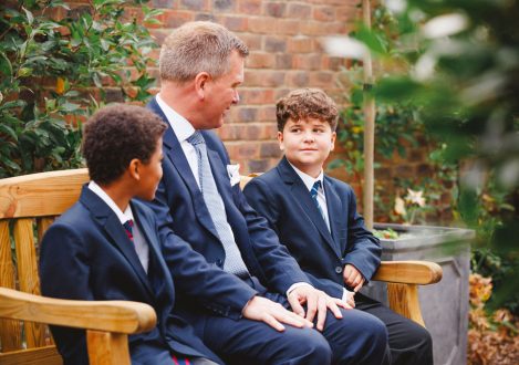 2 students with a teacher on a bench