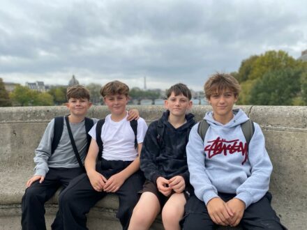 4 students sat on a concrete bench