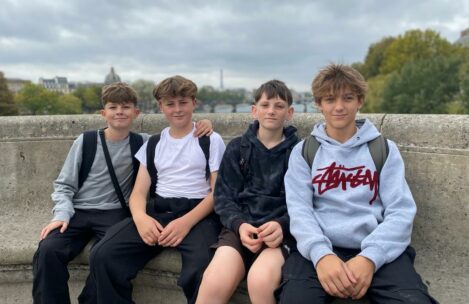 4 students sat on a concrete bench