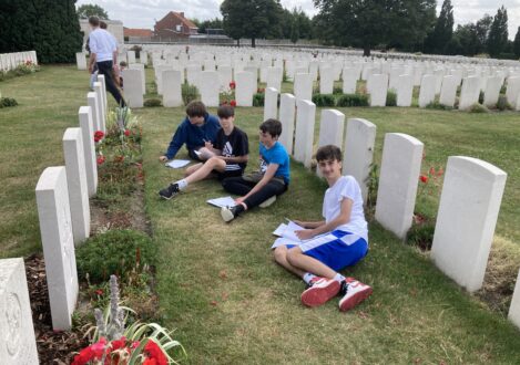 students sat by gravestones