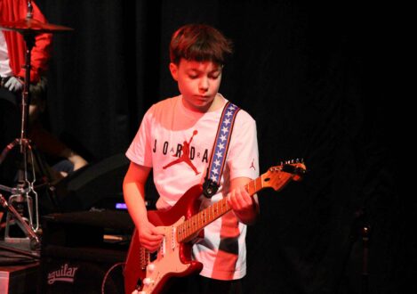 student playing the guitar in a band