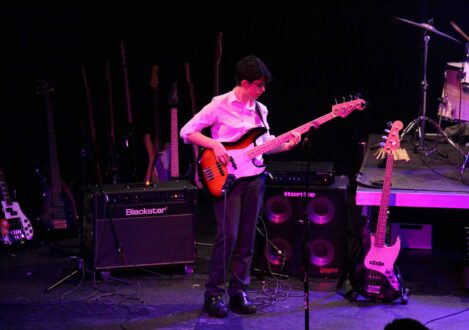 student playing the guitar in a band