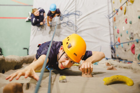 student rock climbing