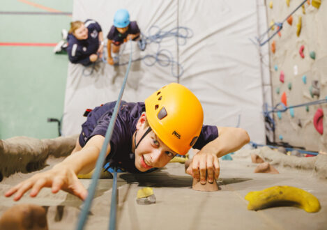 student rock climbing