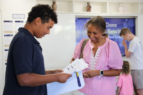 Two people exchange papers in a bright room, smiling as they review documents together, with a blue 'Done' screen in the background.